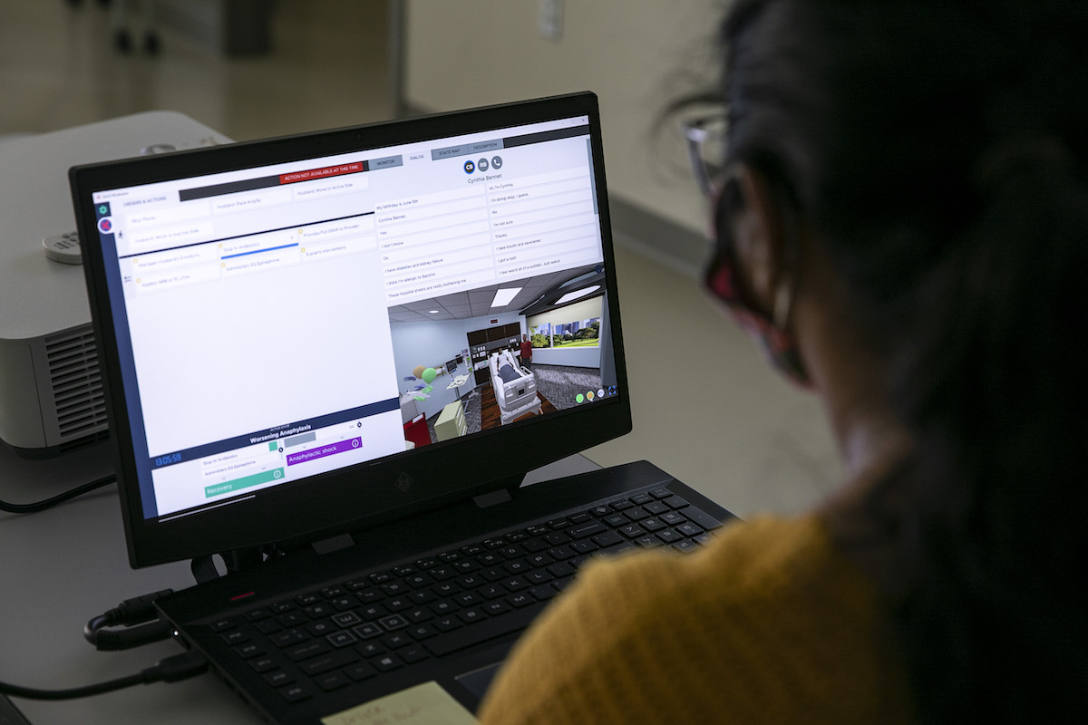 woman watches simulation on laptop