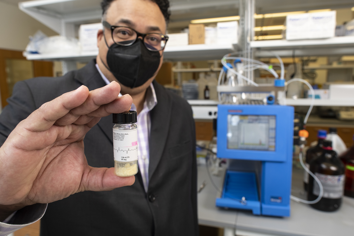 man in lab with vial