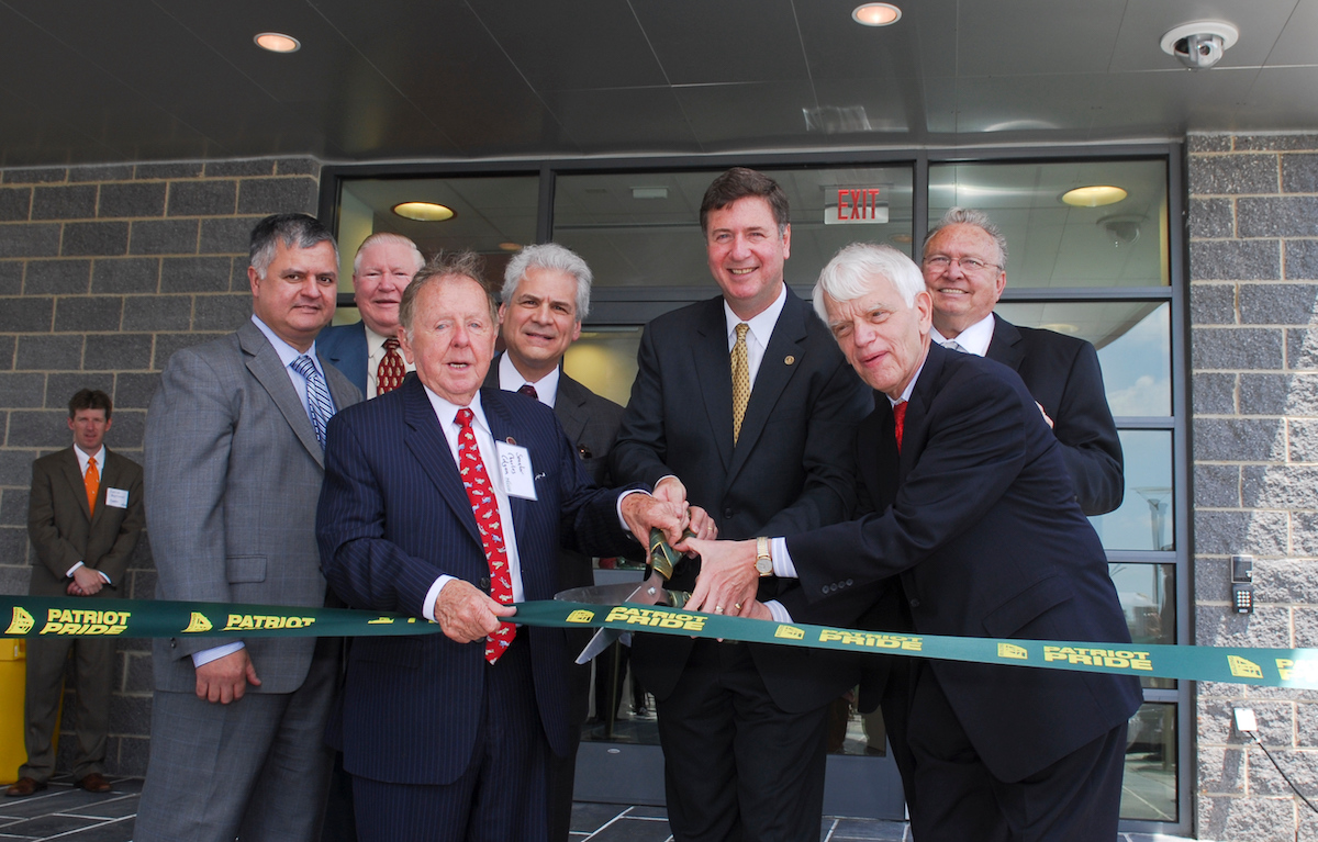 men cutting a ribbon