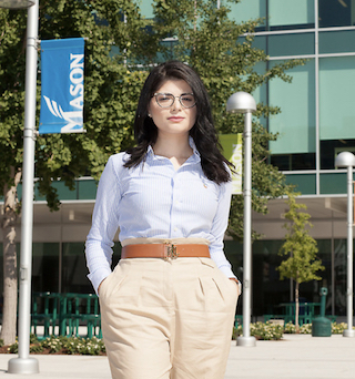 Law student Sally Alghazali stands with her hands in her pockets on the Mason Square campus in Arlington.