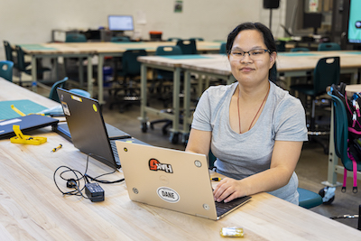 young woman at a work table with laptops