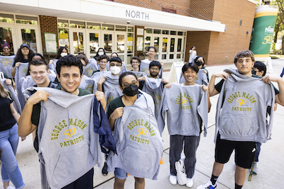 students showing off their Mason hoodies