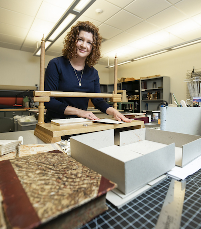 woman working with bookmaking tools on a table