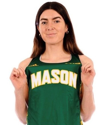 A woman in a green Mason track suit poses for the camera.