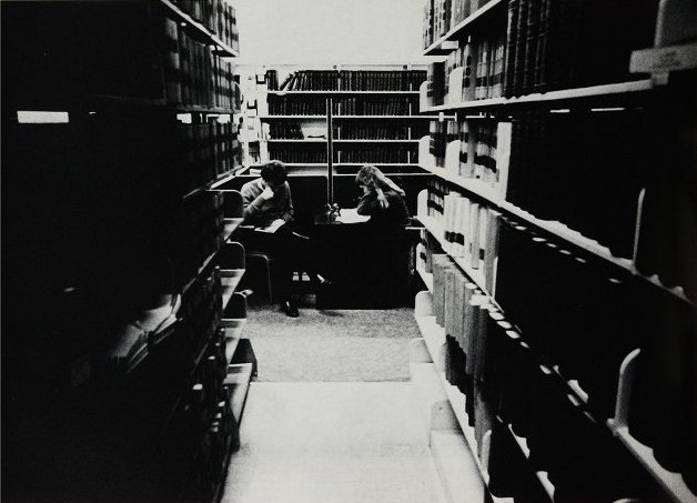 A male and female student studying in the law school library.