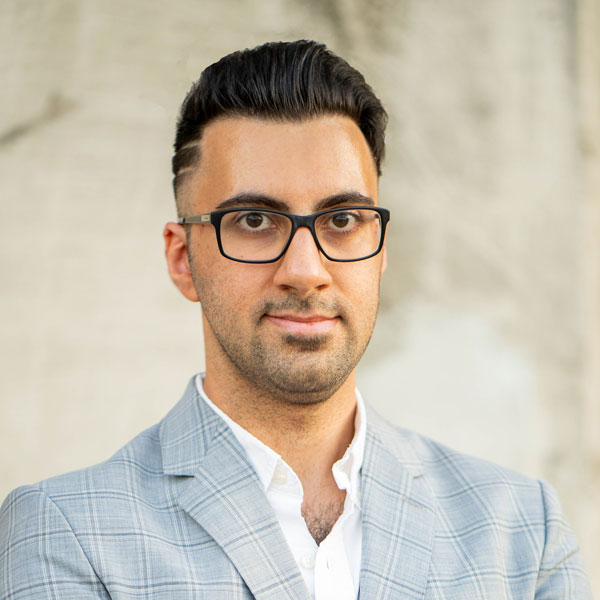 Mason assistant professor Alireza Ermagun wears a gray suit, black glasses, and black hair