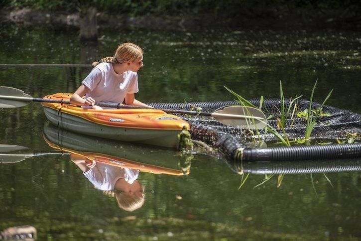 Kennedy Ream sitting in a canoe as she attends to a floating biological island.