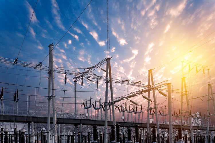 An electrical power grid in front of a sunset