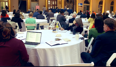 people at tables at a conference