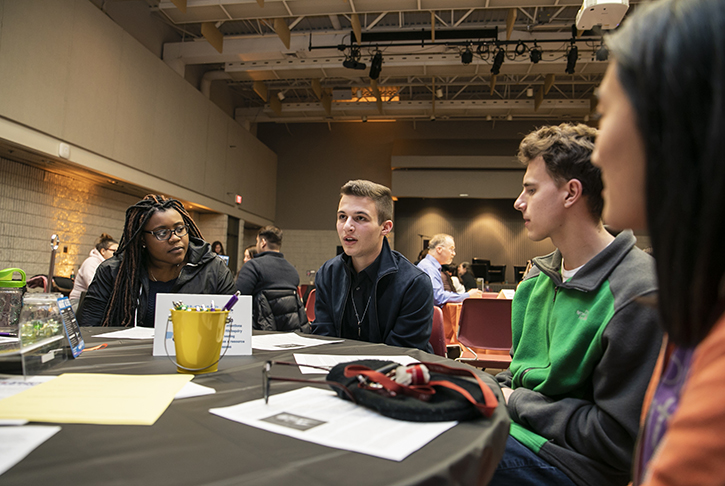 Cameron Kasky sitting with Mason students at a round table.