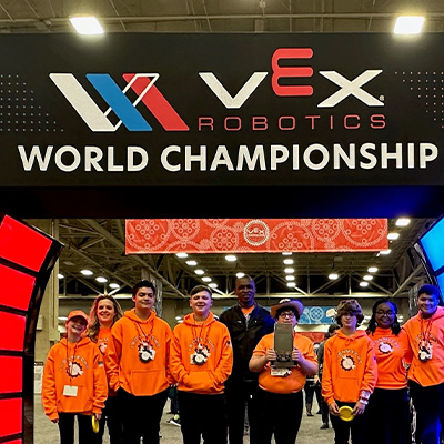 Maria Uriyo (second from right), her husband Newland Agbenowosi (center) and assistant coach, Julie Fant (second from left) with students from their robotics team.