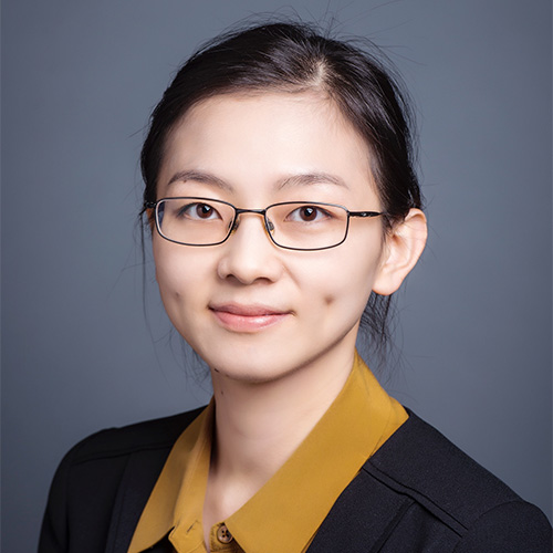 GMU faculty member Pei Dong wears a yellow blouse and dark cardigan