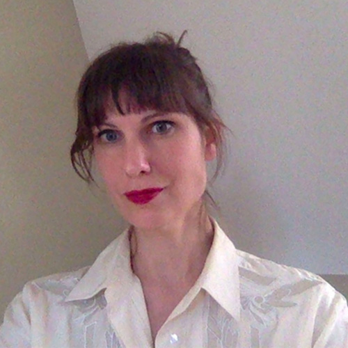 A well-styled Nora McDonald in a white shirt and red lipstick