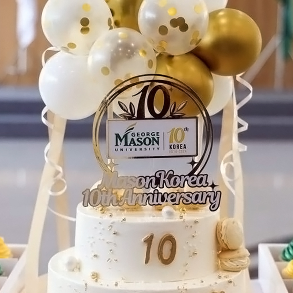 A cake bearing the George Mason University logo, with the text "Mason Korea 10th Anniversary"