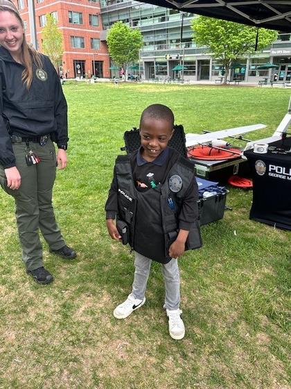 Child tries on a Mason Police vest at Take Your Junior Patriot to Work day
